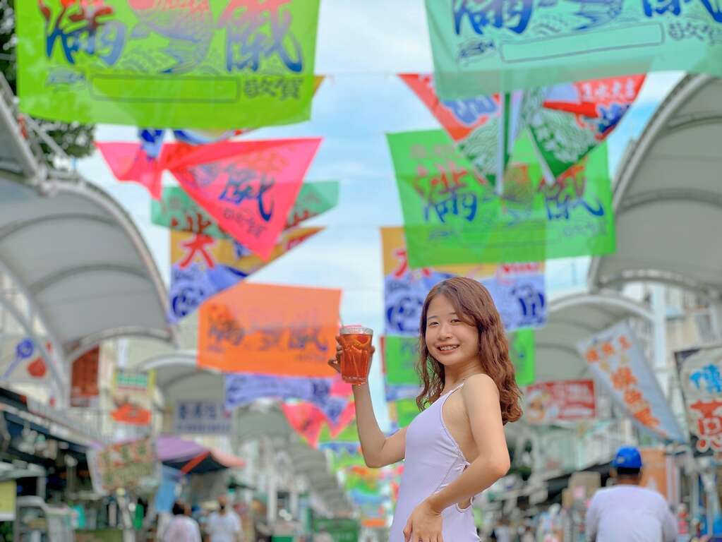 遊客與旗津大街上飄揚上百面漁旗拍照打卡