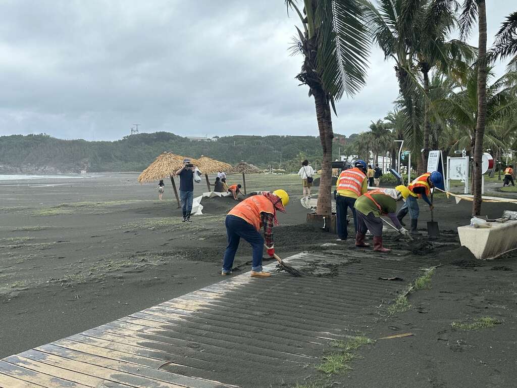 圖九：旗津海岸公園觀光局派員清除堆積海砂，力求最快速度恢復原狀。