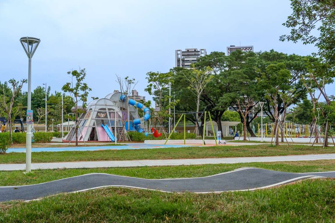 從草坪遠眺多元化的兒童遊戲場全景