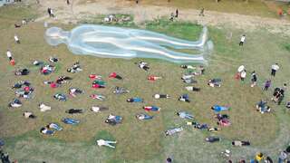 绿草地上空气人与快闪活动民众一同深呼吸