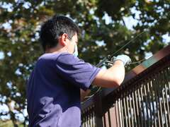 图4.动物展场用来防止野生猕猴侵入的电围篱损坏，保育员进行简易维修