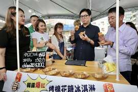 图12.陈其迈现场开心与民众同乐，试做各式冰品，邀请大家到高雄享用美味冰品。