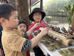 图8 小朋友敲打植物果实制成的乐器